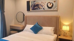Une chambre d’hôtel avec un lit, une table de chevet avec une lampe, un miroir et un tableau au mur.
