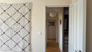 Ein Flur mit Teppich, Holzfußboden und einer Tür zu einem Schrank.