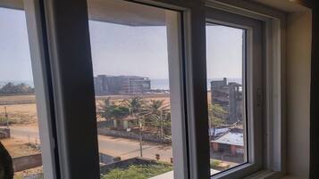 Vista desde una ventana que muestra edificios, una carretera y algo de vegetación.