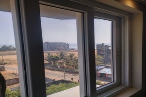 Vista desde una ventana que muestra edificios, una carretera y algo de vegetación.