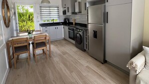 Eine moderne Küche mit grauen Schränken, einem eingebauten Backofen und einer Waschmaschine.