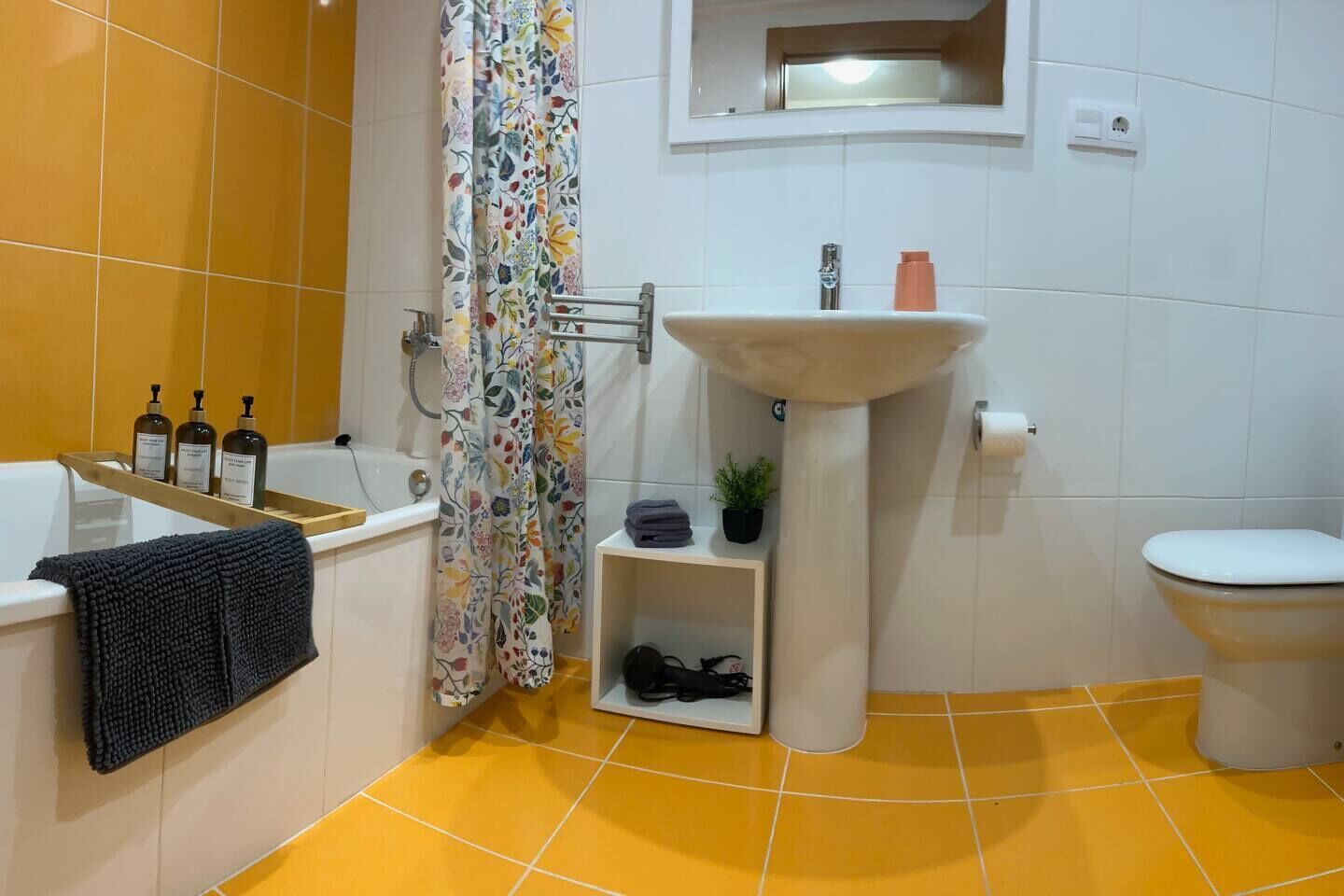 Un baño con bañera, lavamanos, inodoro y cortina de ducha.