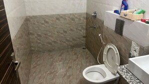 Une salle de bain équipée d’une douche, de toilettes et d’un lavabo avec des articles de toilette.