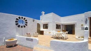 A white building with a circular window, outdoor seating, and a sign that reads "CLEAN ROOM". - Villa Ann Lanzarote (Nazaret)
