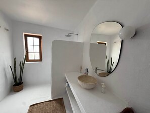 A bathroom with a bathtub, a sink with a large mirror, and a window. - Villa Ann Lanzarote (Nazaret)