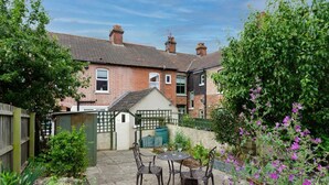 A residential backyard with a patio, chairs, a small shed, and a garden. - Beecroft Cottage - sleeps 4 guests  in 2 bedrooms (Cromer)