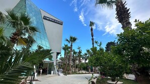Un hôtel moderne doté d’une façade en verre et d’une enseigne indiquant « HÔTEL LONA ».