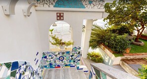 A staircase with mosaic tiles leading to a white door with a cross symbol.
