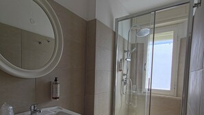 A bathroom with a sink, mirror, and shower. - Hotel Ornella (Bellaria-Igea Marina)