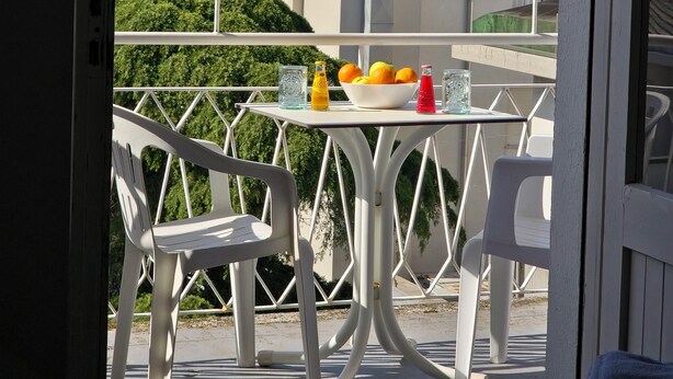 A balcony with a table, chairs, and a bowl of fruit. - Hotel Ornella (Bellaria-Igea Marina)