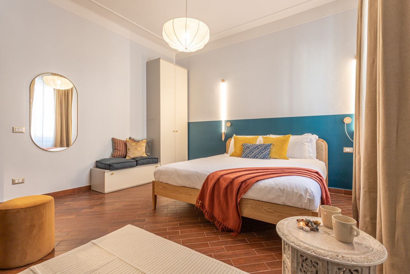 A bedroom with a bed, bedside table, and a wardrobe.