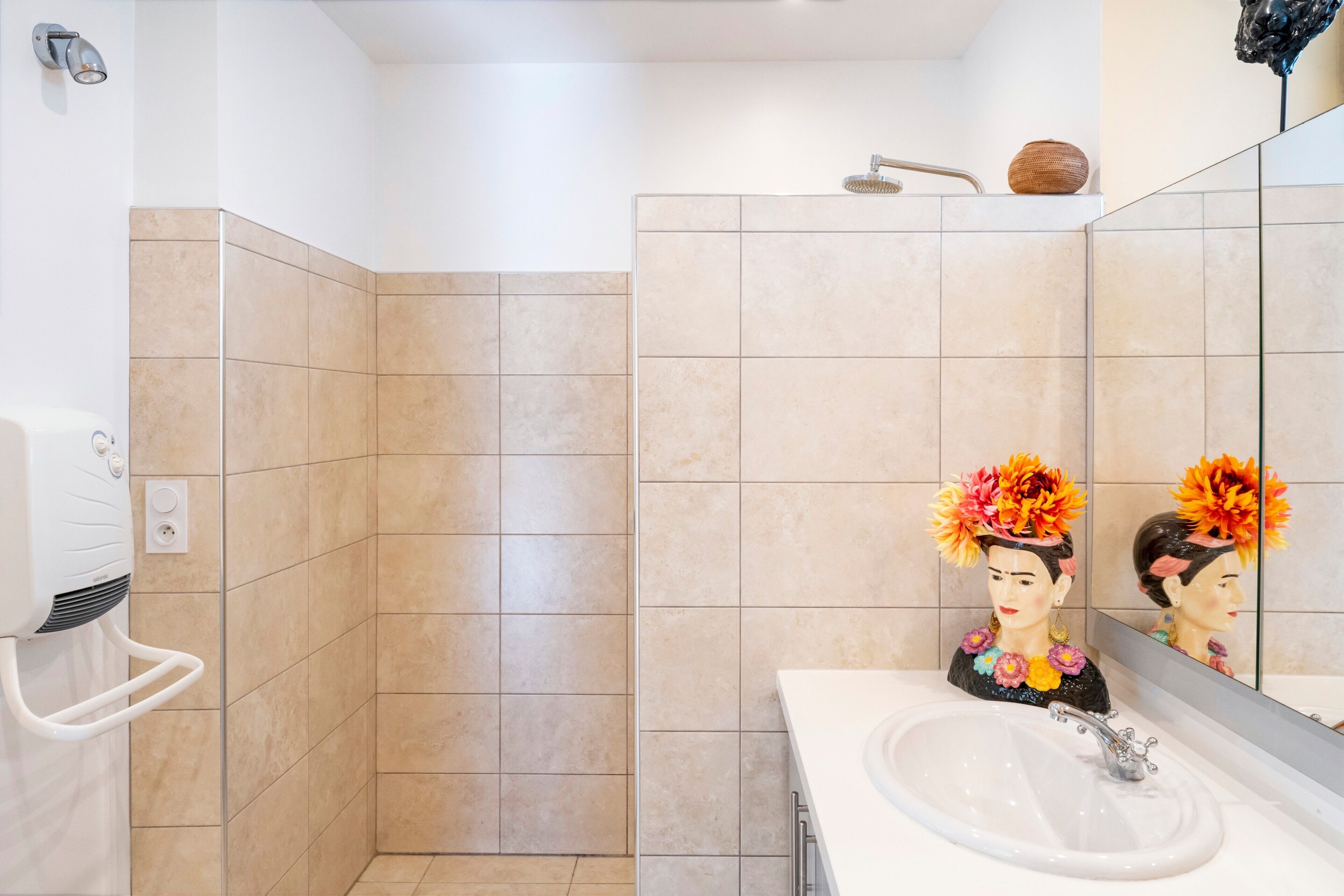 A bathroom with a shower, a sink, and a mirror.