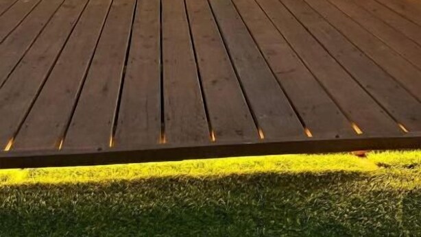 A wooden deck with two chairs and two umbrellas, overlooking a landscape with hills and a body of water. - suite la pennichella (Agropoli)