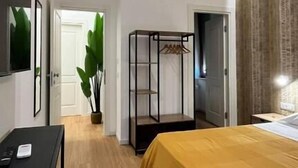 A bedroom with a bed, a desk, a wardrobe, and a plant. - suite la pennichella (Agropoli)