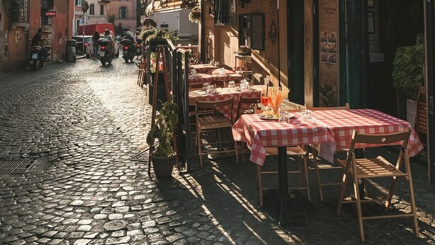 A cobblestone street with outdoor seating at a pizzeria. - Colosseum: Entire Guest House (2BR en-suite/2BA) (Roma)