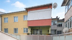 Un edificio residencial de varios pisos con un área de balcón con tejas.