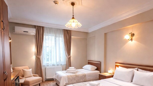 Habitación de hotel con dos camas, una zona de estar y vistas al exterior.