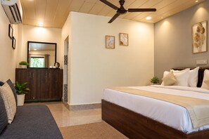 A bedroom with a bed, a ceiling fan, a dresser, and a mirror.