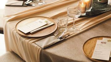 A table set with a menu, glasses, and a candle.