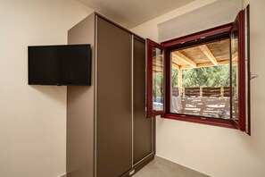 A room with a sliding door, a mounted television, and a window with a view of the outside. - Salt Vibe Residence - Dione Residence, close to the sea (Vasilikos)