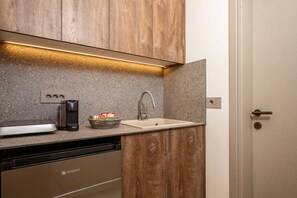 Eine Küche mit Holzausstattung, einem Geschirrspüler, einer Kaffeemaschine und einem Spülbecken.