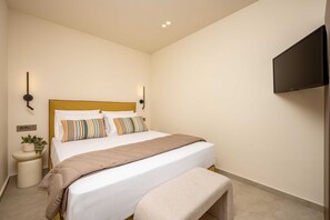 A bedroom with a bed, bedside tables, a TV, and a wall-mounted light fixture. - Salt Vibe Residence - Dione Residence, close to the sea (Vasilikos)