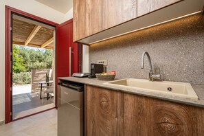 A modern kitchen with wooden cabinets, a granite countertop, a stainless steel sink, and a built-in dishwasher. - Salt Vibe Residence - Dione Residence, close to the sea (Vasilikos)