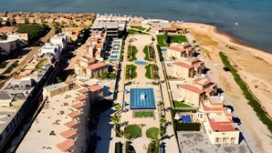 An aerial view of a coastal resort with multiple buildings, a central swimming pool, and a beach area. - Arena Beach Resort (Hurghada)