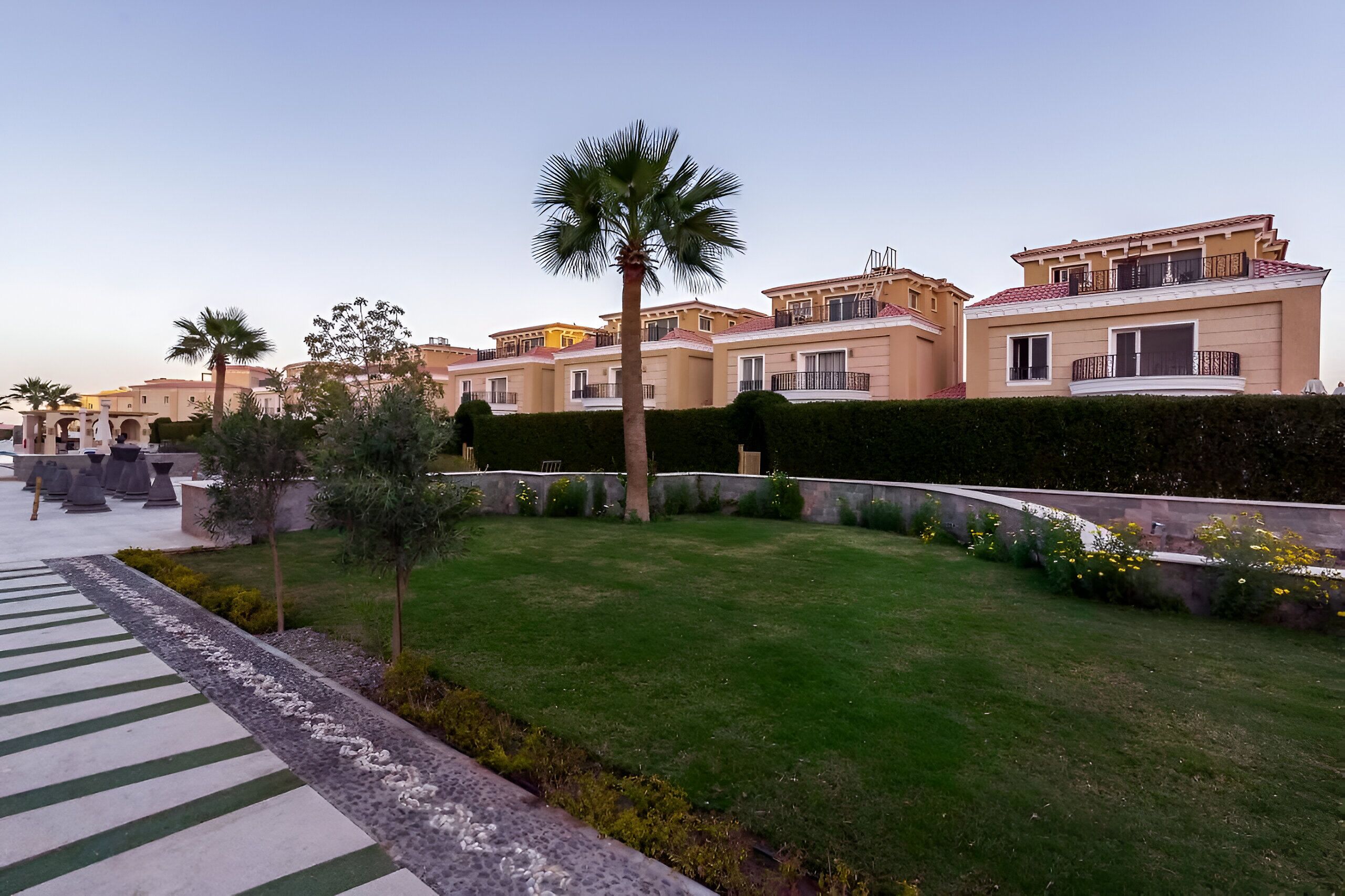 Un barrio residencial con casas modernas, un césped cuidado y un cielo despejado.