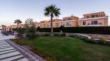 Un barrio residencial con casas modernas, un césped cuidado y un cielo despejado.