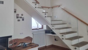 Ein modernes Interieur mit einer Glasstufen-Wendeltreppe, Holzboden und minimalistischem Design.