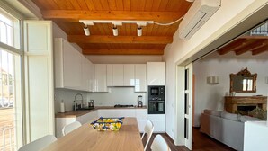 Eine moderne Küche mit weißen Schränken, einem Holzespeisetisch und einem eingebauten Backofen.