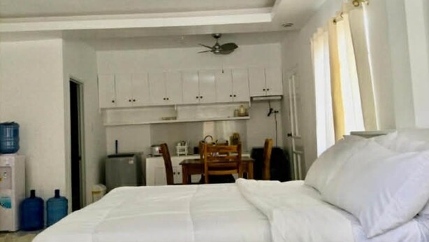 Een hotelkamer met een bed, bureau en kitchenette.