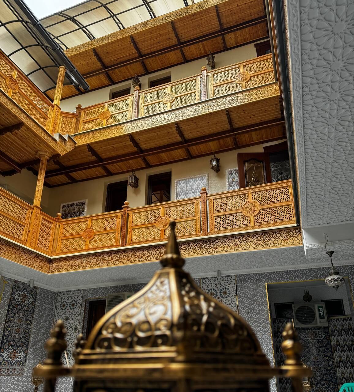 A multi-level interior with ornate balconies, a central decorative structure, and patterned walls.