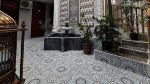 Un intérieur spacieux avec un plafond haut, des motifs complexes sur les murs et un sol à motifs.
