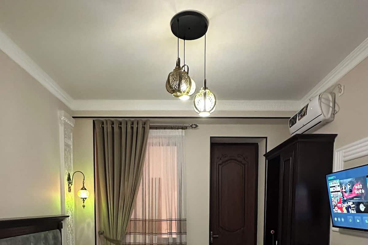 A hotel room with a bed, a desk, a television, and a window with curtains.