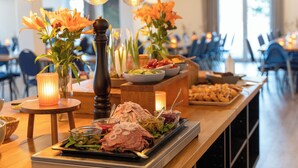 A buffet setup with various food items, candles, and flowers. - Feriecenter Slettestrand (Fjerritslev)