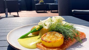 A plate of food on an outdoor table with a building in the background.