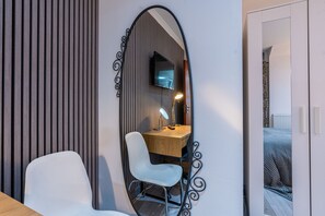 A modern room with a wooden desk, a white chair, a mirror, and a television. - Fulham 6BR 6BA Tube Family London (London)