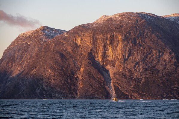 A mountainous landscape with a boat in the foreground. - Hotel Aurora (Nuuk)