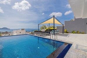 A swimming pool with a sunshade, lounge chairs, and a view of the sea and mountains. - 4 Bedroom Villa with a private pool and incredible views (Peksimet)