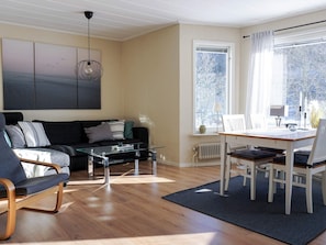 Un salon moderne avec un canapé, une table basse et un coin repas.