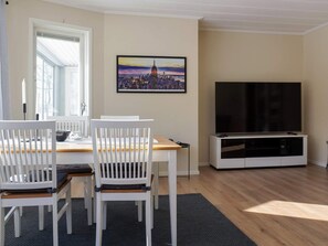 Un espace repas comprenant une table, des chaises et un téléviseur.