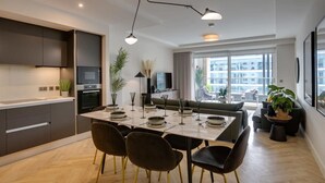 Una cocina moderna con zona de comedor, ventanas grandes y vistas a la ciudad.