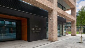 Un edificio moderno con una entrada destacada que reza 'The Benson Building'.