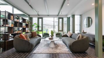A modern living room with a sofa set, a coffee table, and a bookshelf.