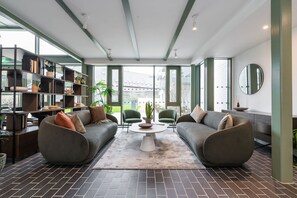 Un salon moderne comprenant un canapé, une table basse et une bibliothèque.