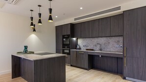 A modern kitchen with dark wood cabinets, a central island, and pendant lighting. - The Oslo by Dublin At Home (Dublin)