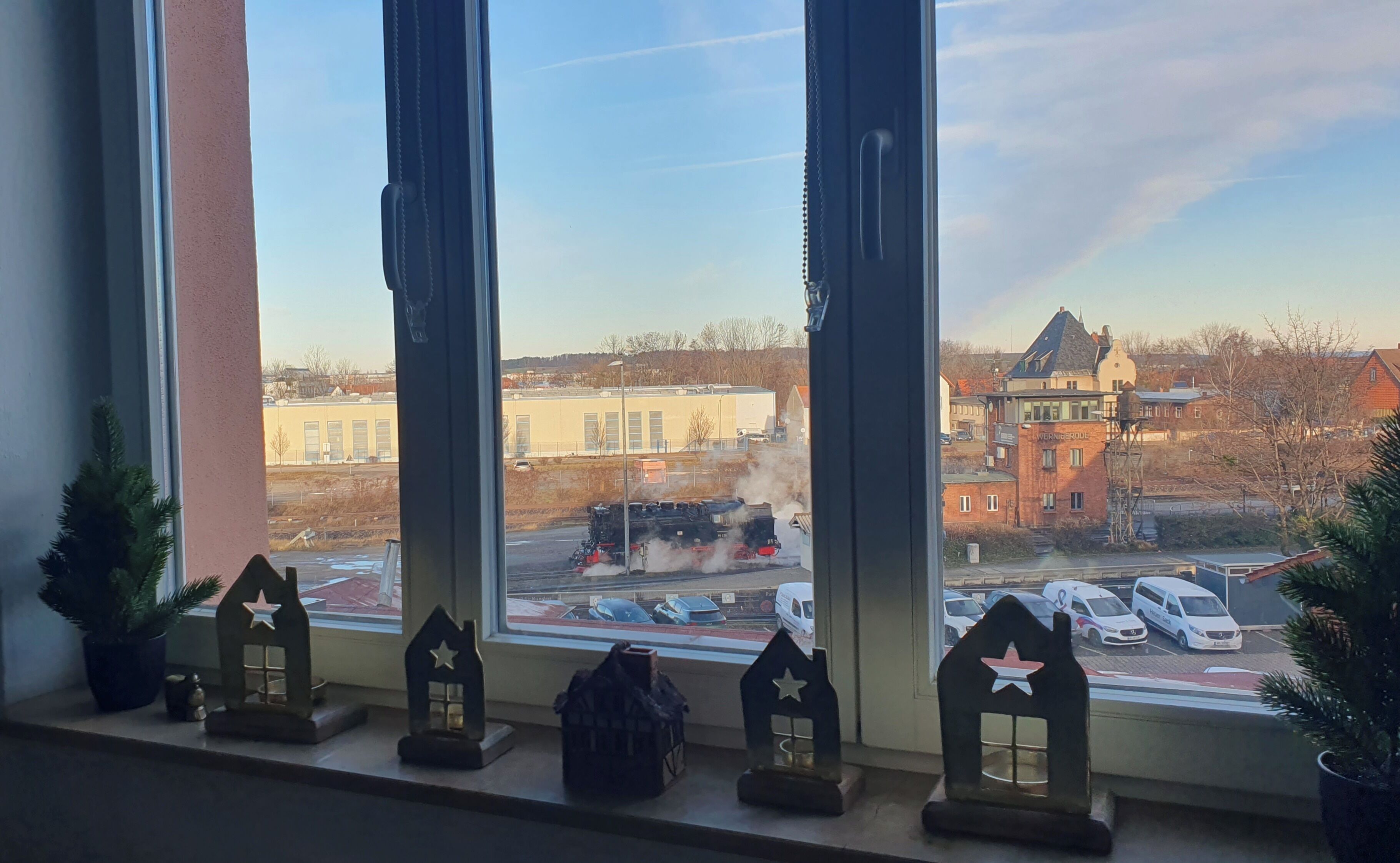 A view through a window with three small houses as decorations.