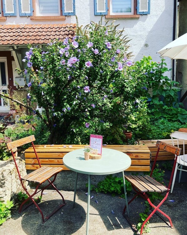 Ein Holz-Bänke- und Tisch-Set draußen mit einer Speisekartenständer.
